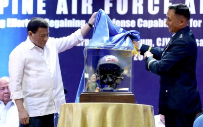<p>President Rodrigo Roa Duterte receives a fighter pilot's helmet as token during the 71st founding anniversary of the Philippine Air Force (PAF) at the Multi-Purpose Gymnasium in Colonel Jesus Villamor Air Base (CJVAB), Pasay City on July 3, 2018. Presenting the token is PAF Commander Lieutenant General Galileo Kintanar, Jr. <em>(Robinson Niñal/Presidential Photo)</em></p>